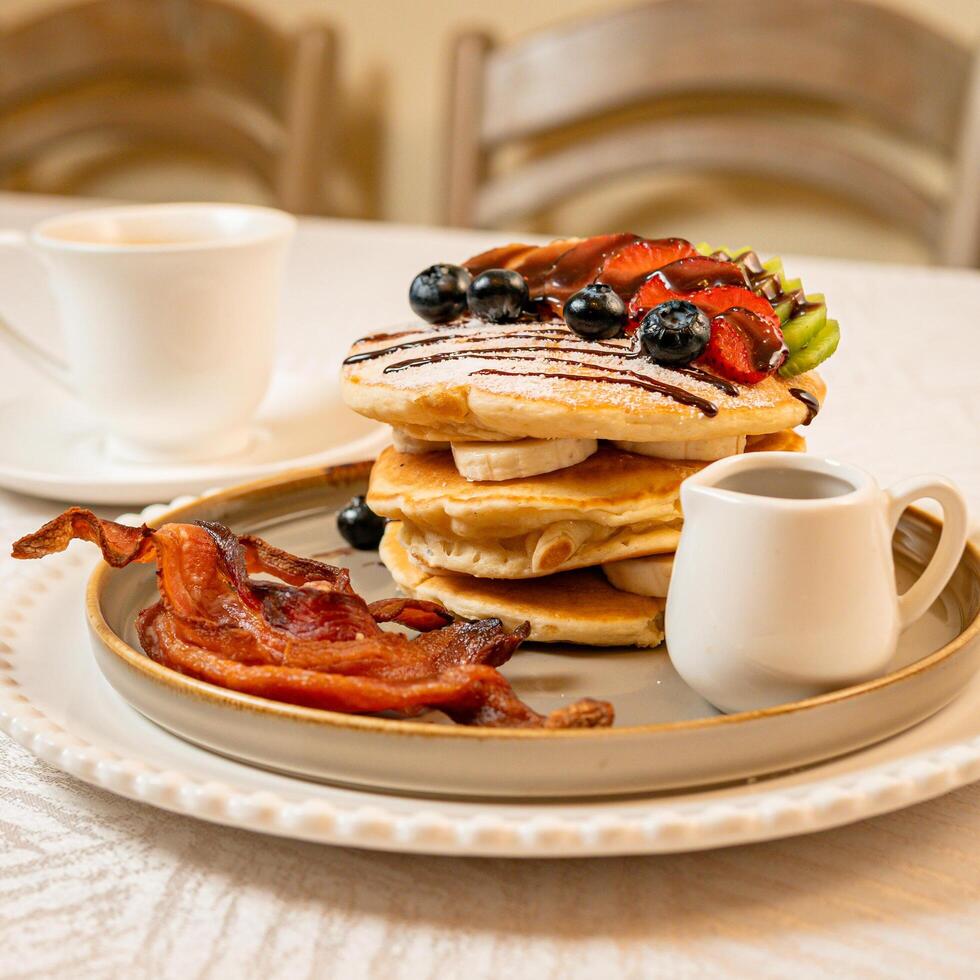 Fruit crepes with chocolate and maple syrup for breakfast photo