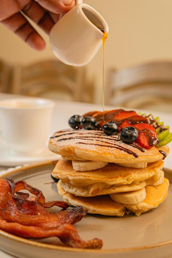 Fruit crepes with chocolate and maple syrup for breakfast photo