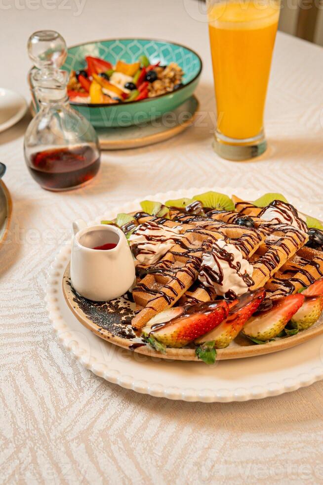 Fruit crepes with chocolate and maple syrup for breakfast photo