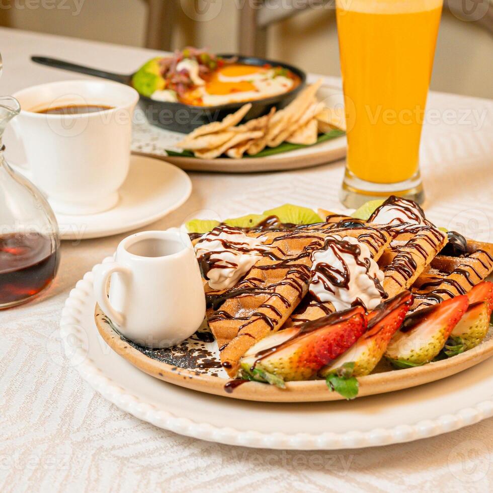 Fruit crepes with chocolate and maple syrup for breakfast photo