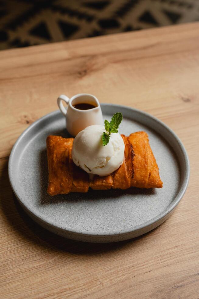 Cheese strudel with ice cream and caramel sauce drizzling on top. photo