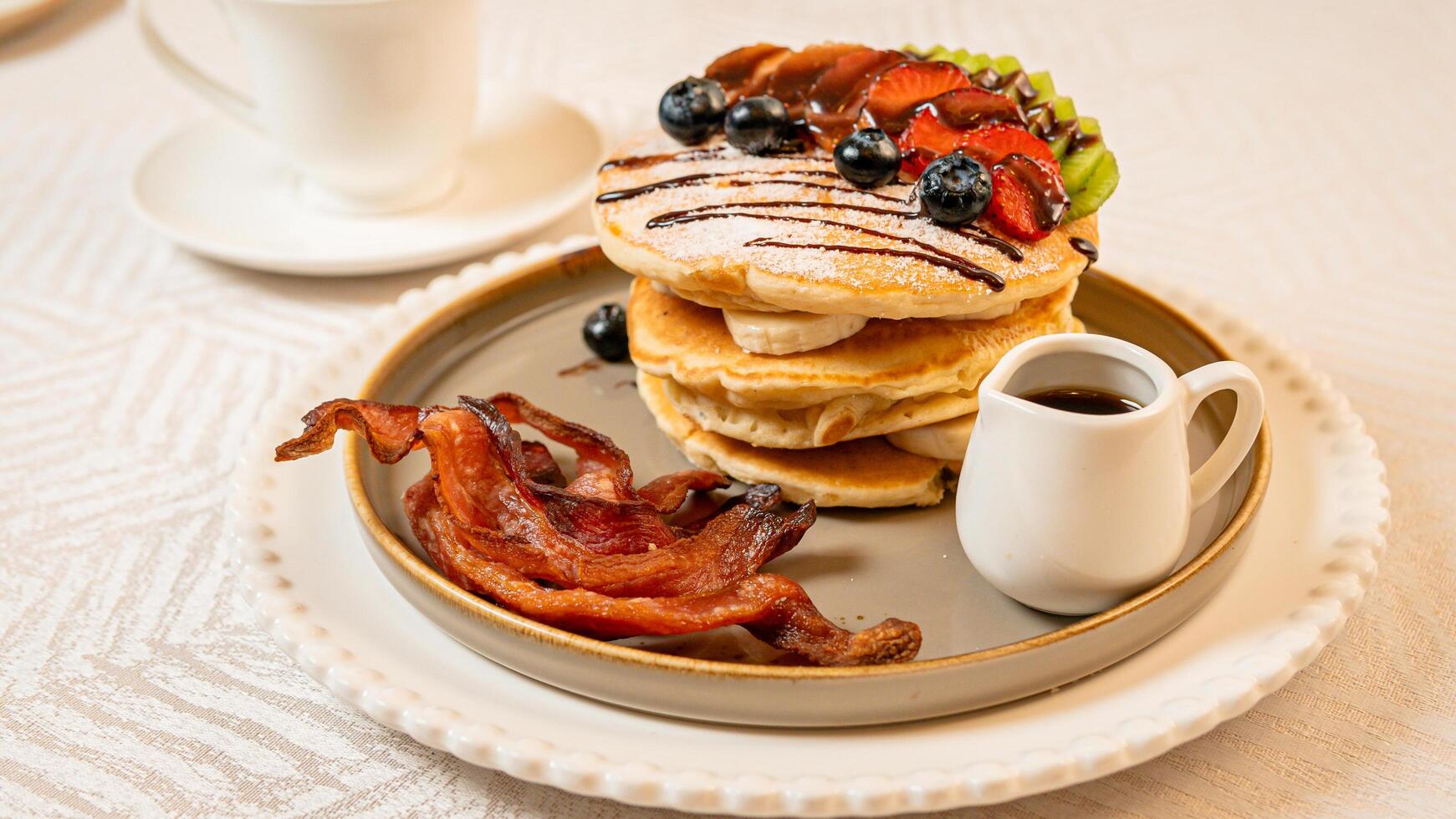 Fruit crepes with chocolate and maple syrup for breakfast photo