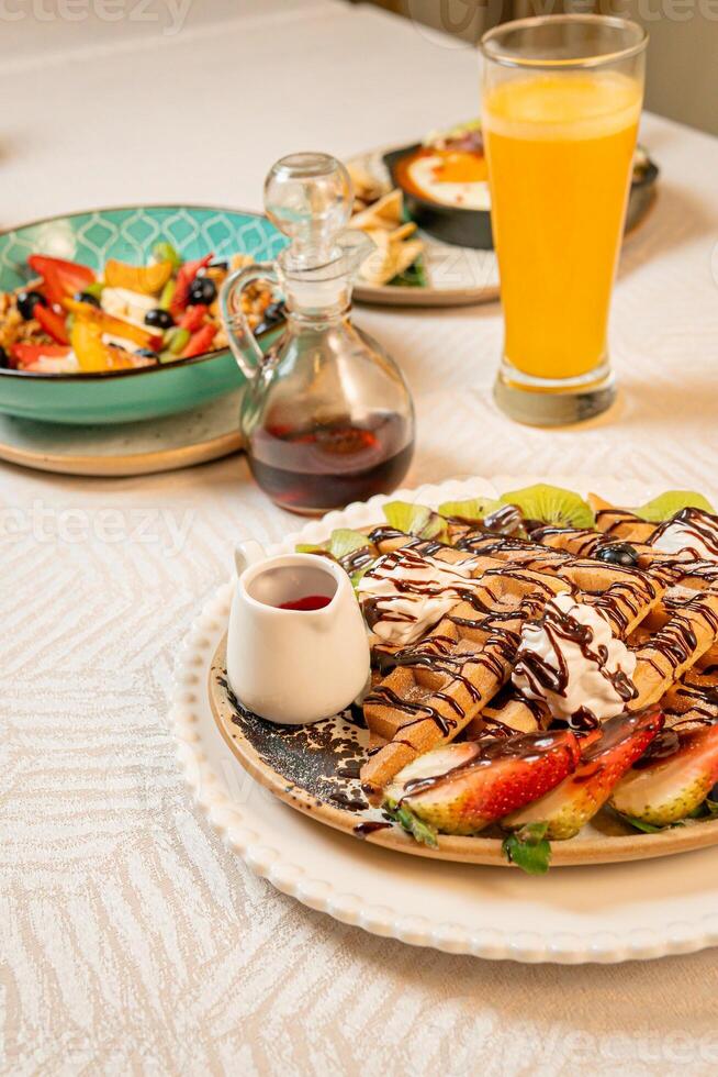 Fruit crepes with chocolate and maple syrup for breakfast photo