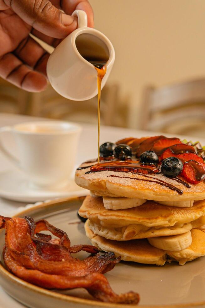 Fruit crepes with chocolate and maple syrup for breakfast photo