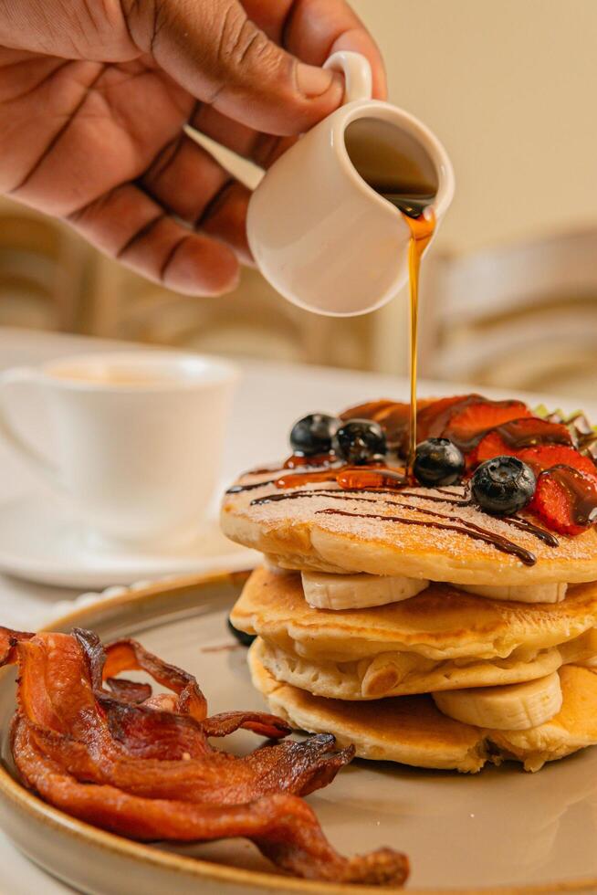 Fruit crepes with chocolate and maple syrup for breakfast photo