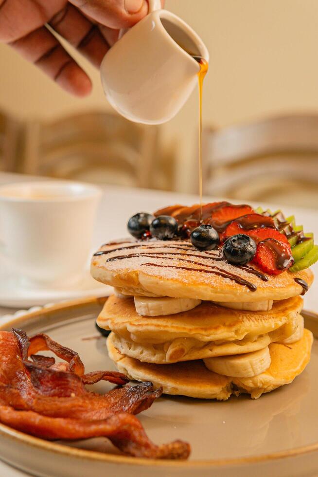 Fruit crepes with chocolate and maple syrup for breakfast photo