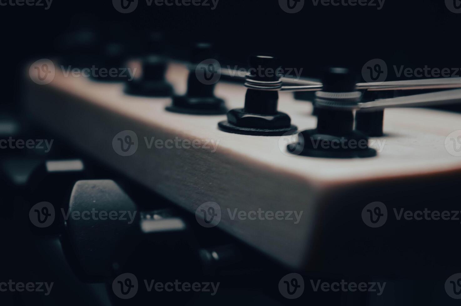 Abstract photo of an electric guitar and its parts macro photo. Music wallpaper and banner for string music album. High quality photo guitar in dark with light reflected in the lacquered surface.