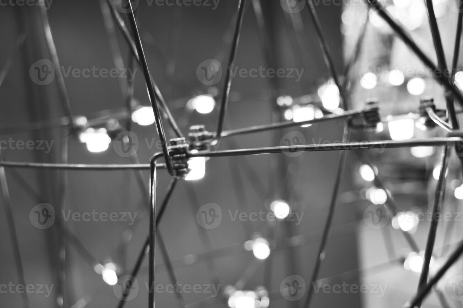 abstract background is a metal structure made of thin rods with light bulbs in a geometric sequence. strange art objects for home and office. High quality photo