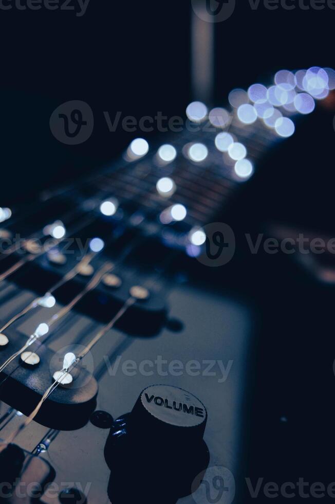 Abstract photo of an electric guitar and its parts macro photo. Music wallpaper and banner for string music album. High quality photo guitar in dark with light reflected in the lacquered surface.