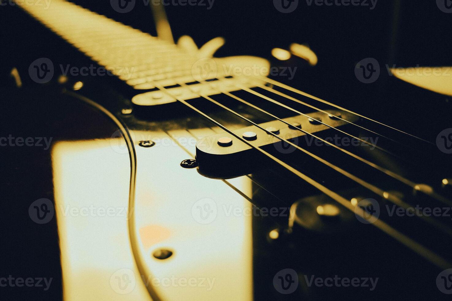 Abstract photo of an electric guitar and its parts macro photo. Music wallpaper and banner for string music album. High quality photo guitar in dark with light reflected in the lacquered surface.