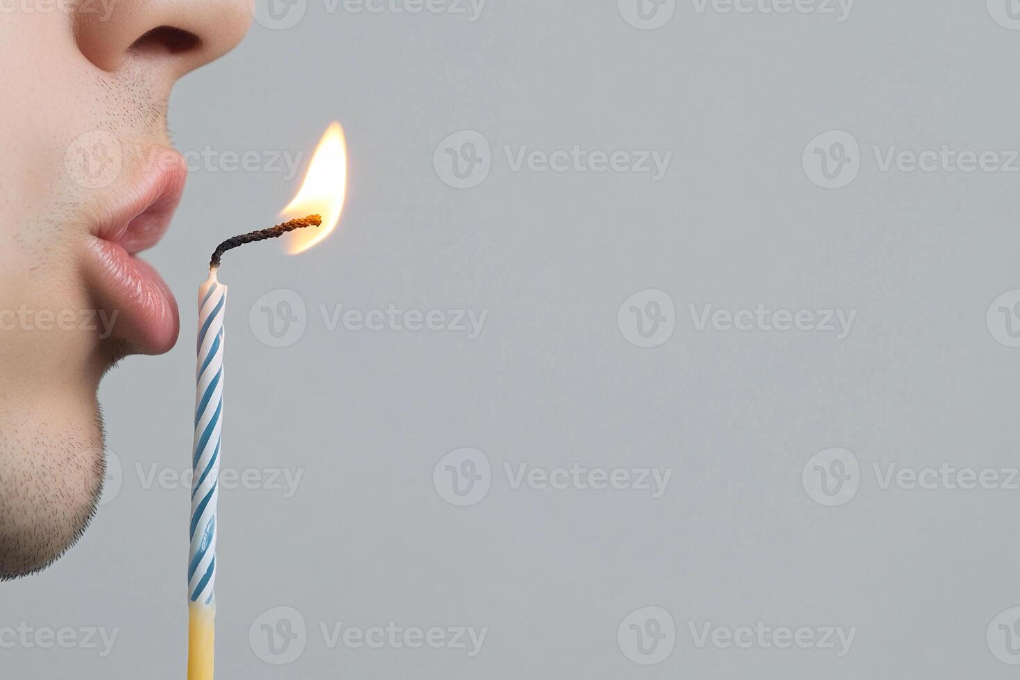 A man blowing out a candle with a lit match photo