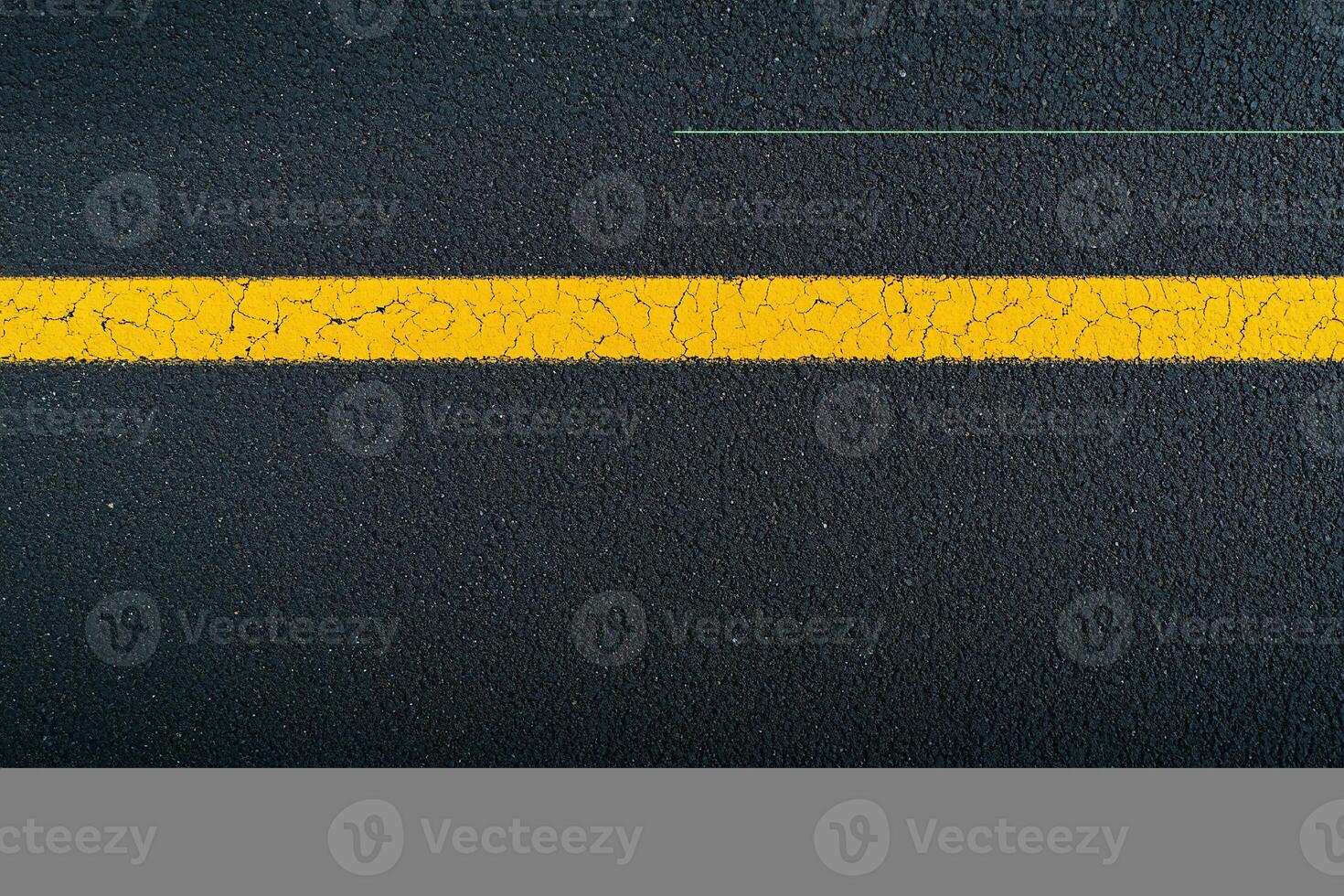 A yellow line on the asphalt with a black background photo