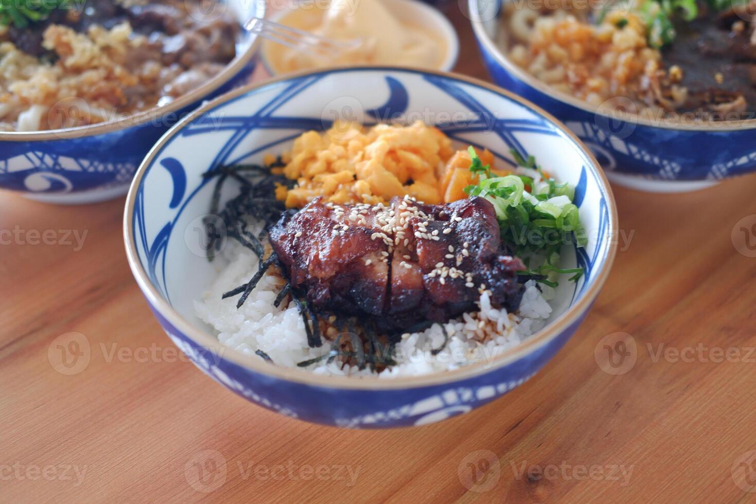 Each bowl contains different ingredients such as meats, vegetables, and rice, garnished with green herbs photo