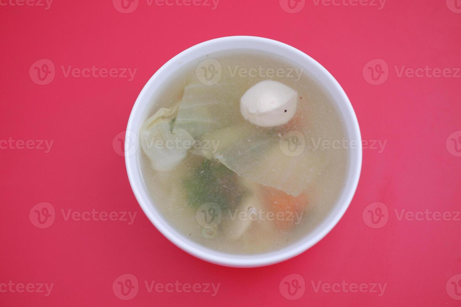 A bowl of soup on a red table photo