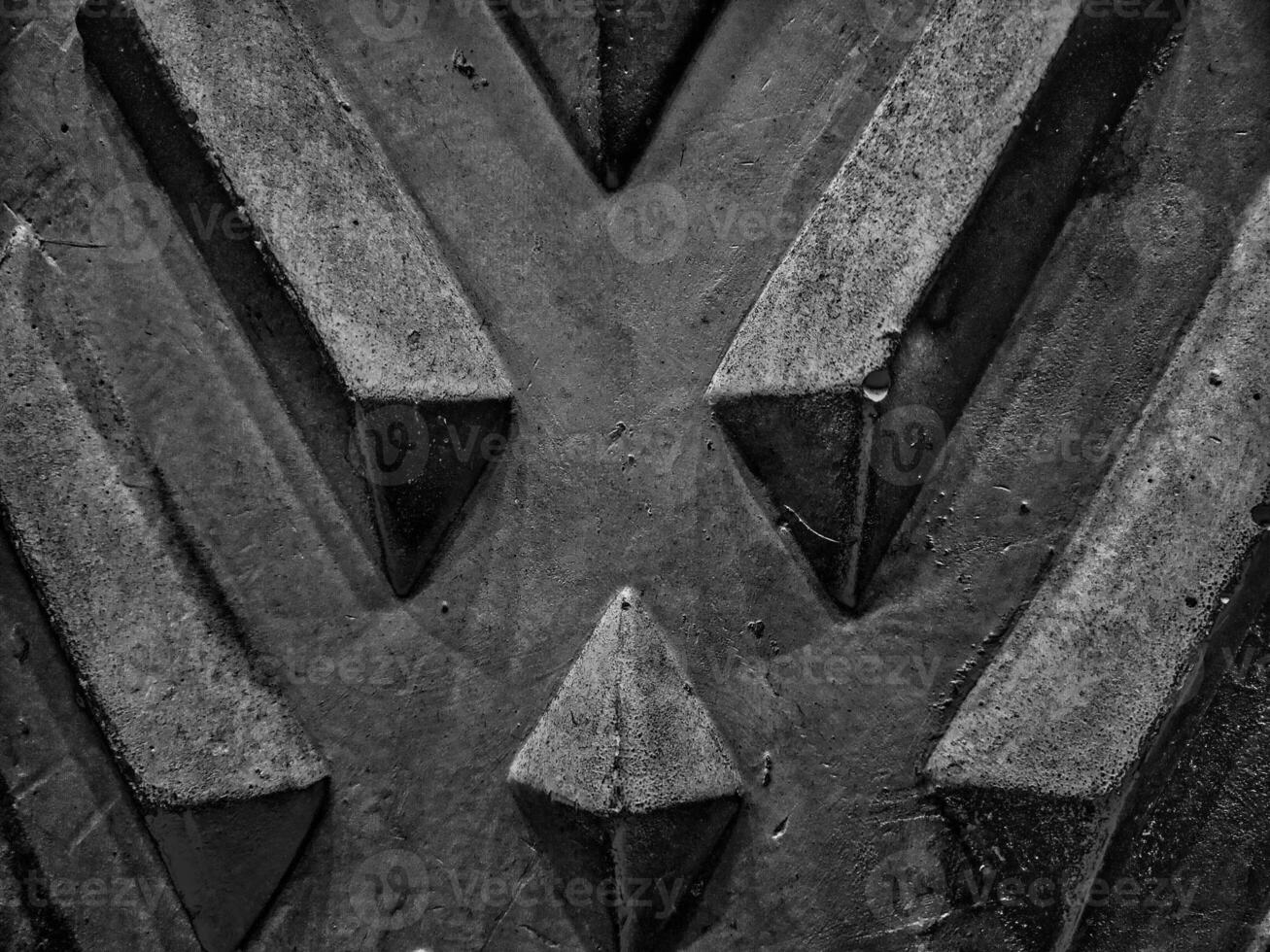 A diamond patterned wall with its textured surface and interplay of light and shadow enhancing the geometric design in picturesque black and white thus reveals intricate details in close ups. photo