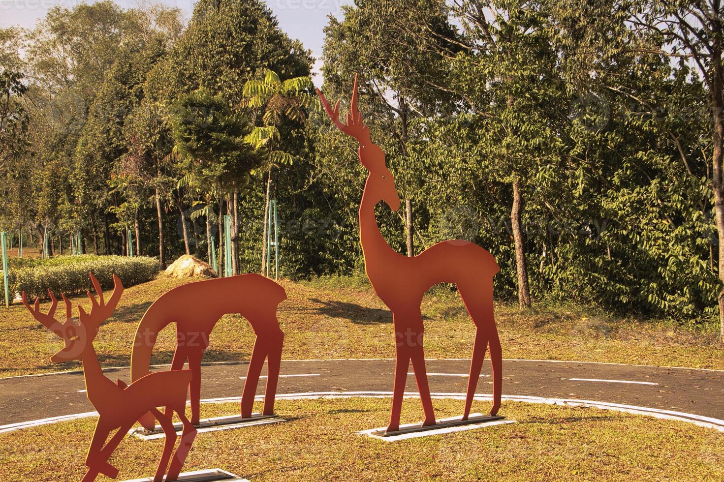 A park with vibrant metal giraffe sculptures painted in gradient colors stands out against the greenery in Taman Tasik Puteri Ijok. photo