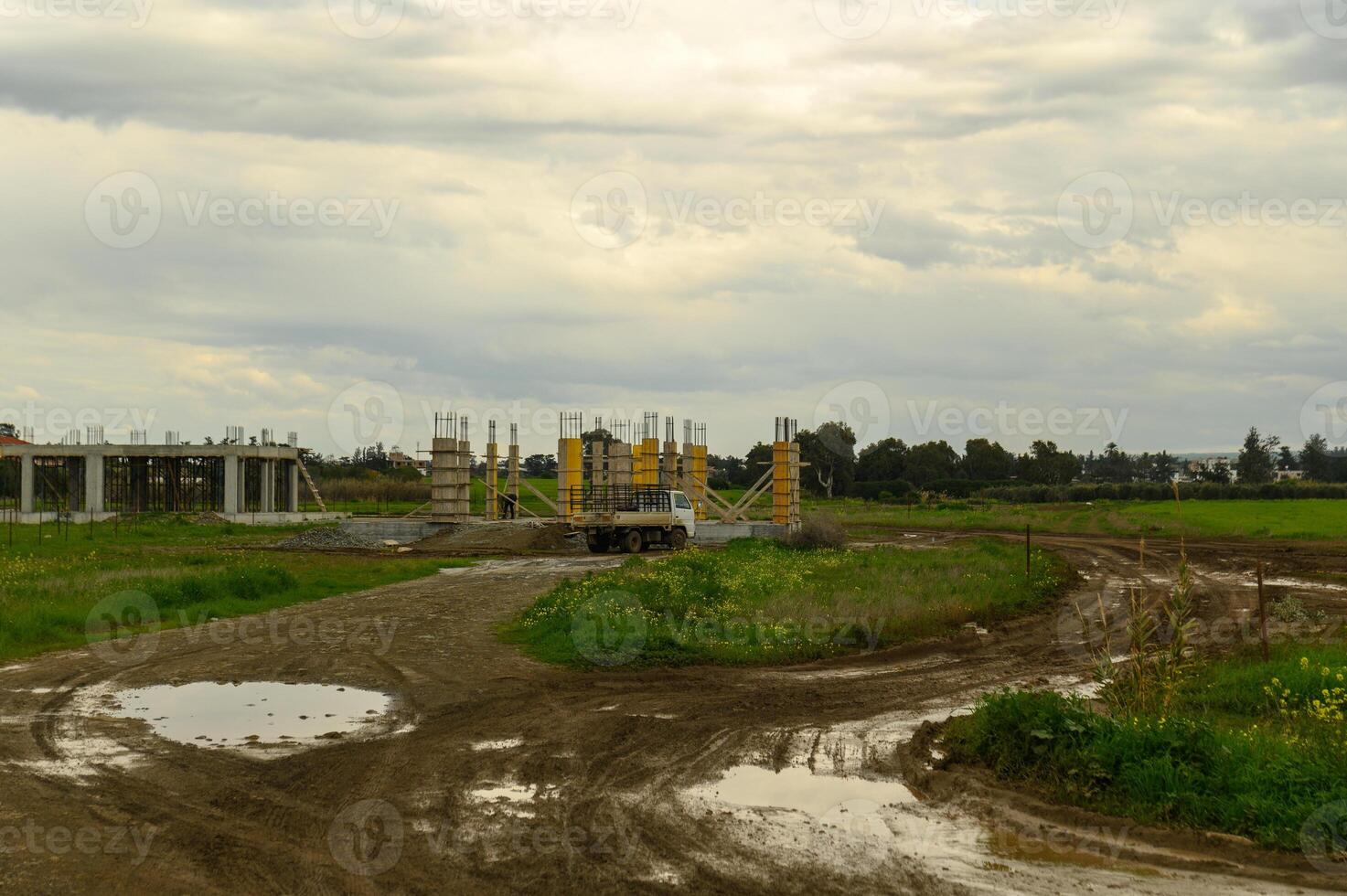 Construction site in an open field under cloudy skies during late afternoon breaks in a rural landscape photo