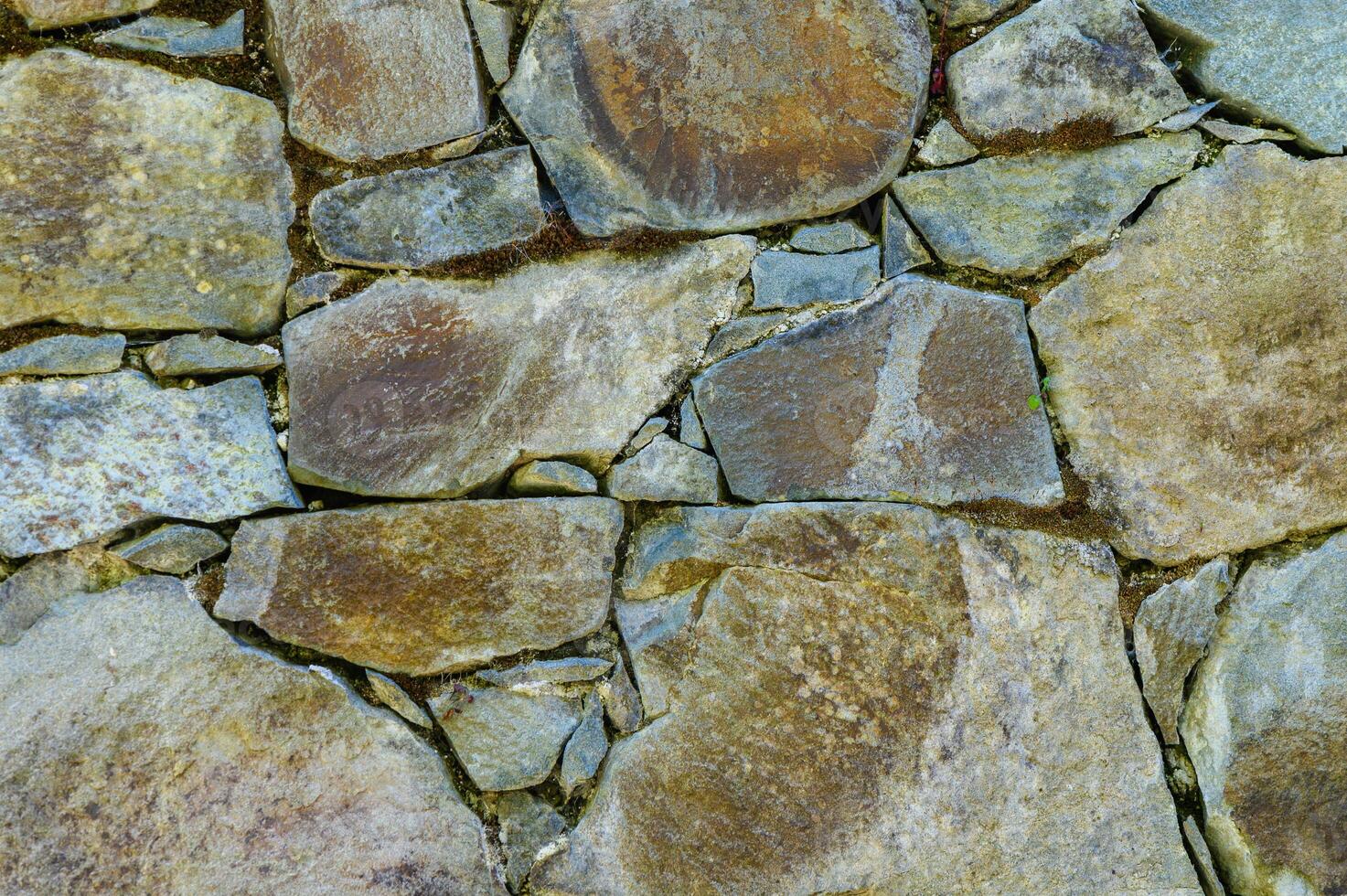 Natural stone wall texture featuring rich earth tones and varied stone shapes in a rustic setting photo