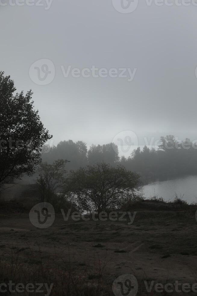 Foggy morning in autumn landscape with lake and mist photo