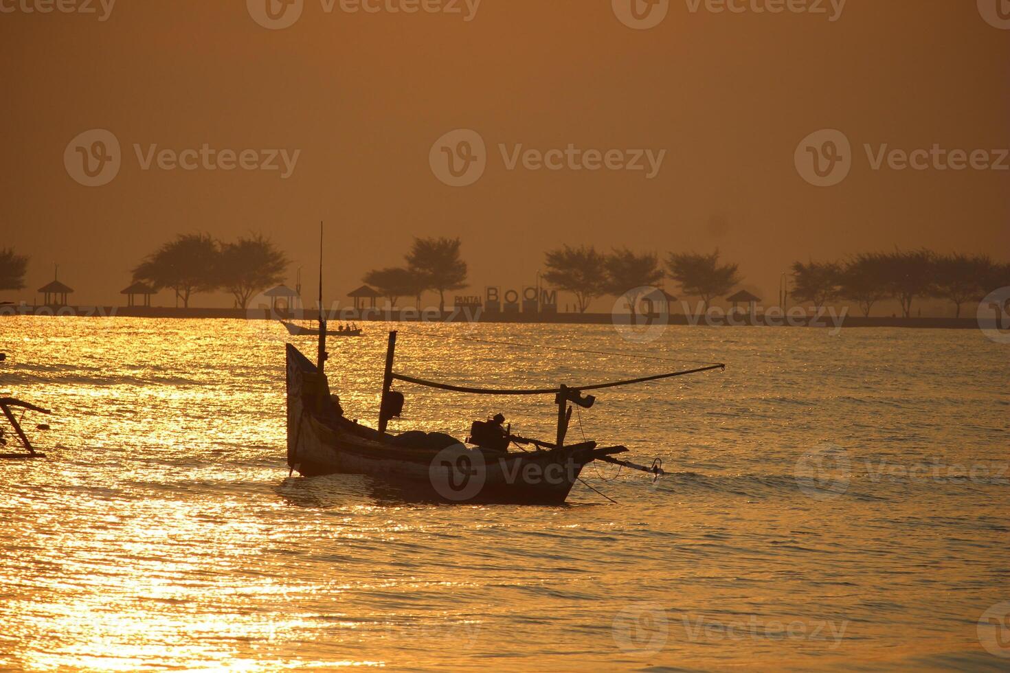 silhouette of a boat on the sea behind the red rising sun in the morning photo