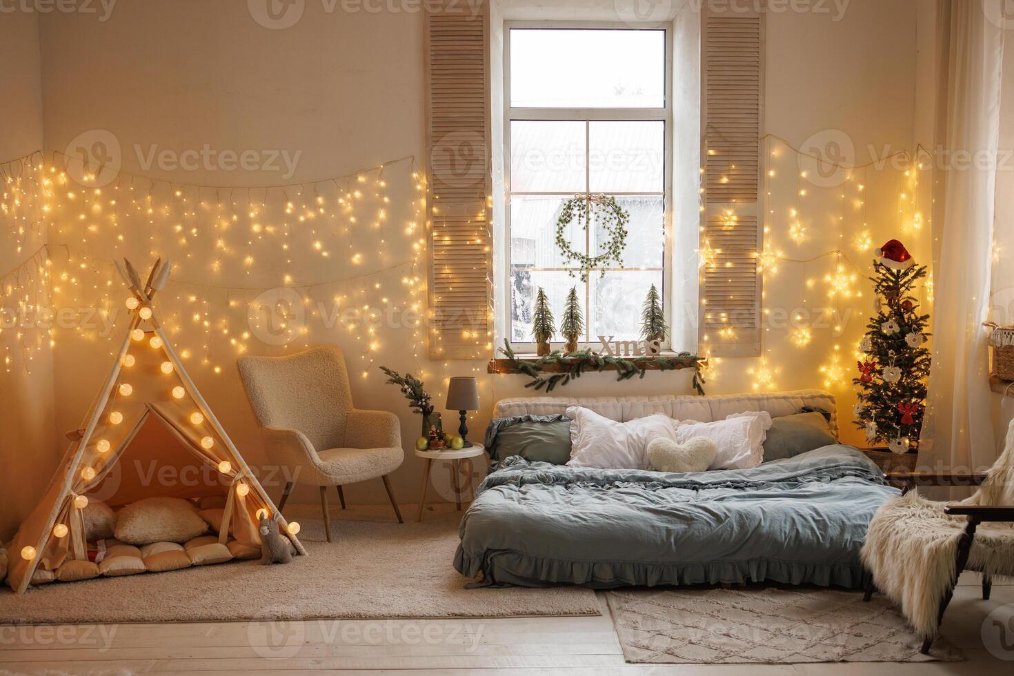 a cozy room with a bed and a children's area, decorated with Christmas garlands and a tree photo