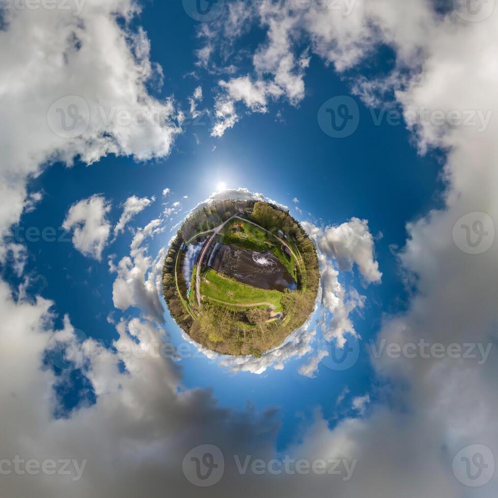 simple little tiny planet without buildings in blue sky with sun and beautiful clouds. Transformation of spherical panorama 360 degrees. Spherical abstract aerial view. Curvature of space. photo