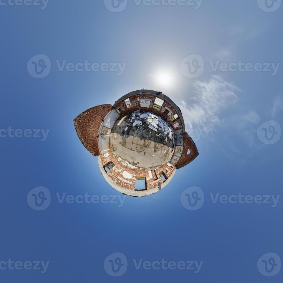 tiny planet in blue sky with clouds of old abandoned ruined church. Transformation of spherical 360 panorama in abstract aerial view. photo