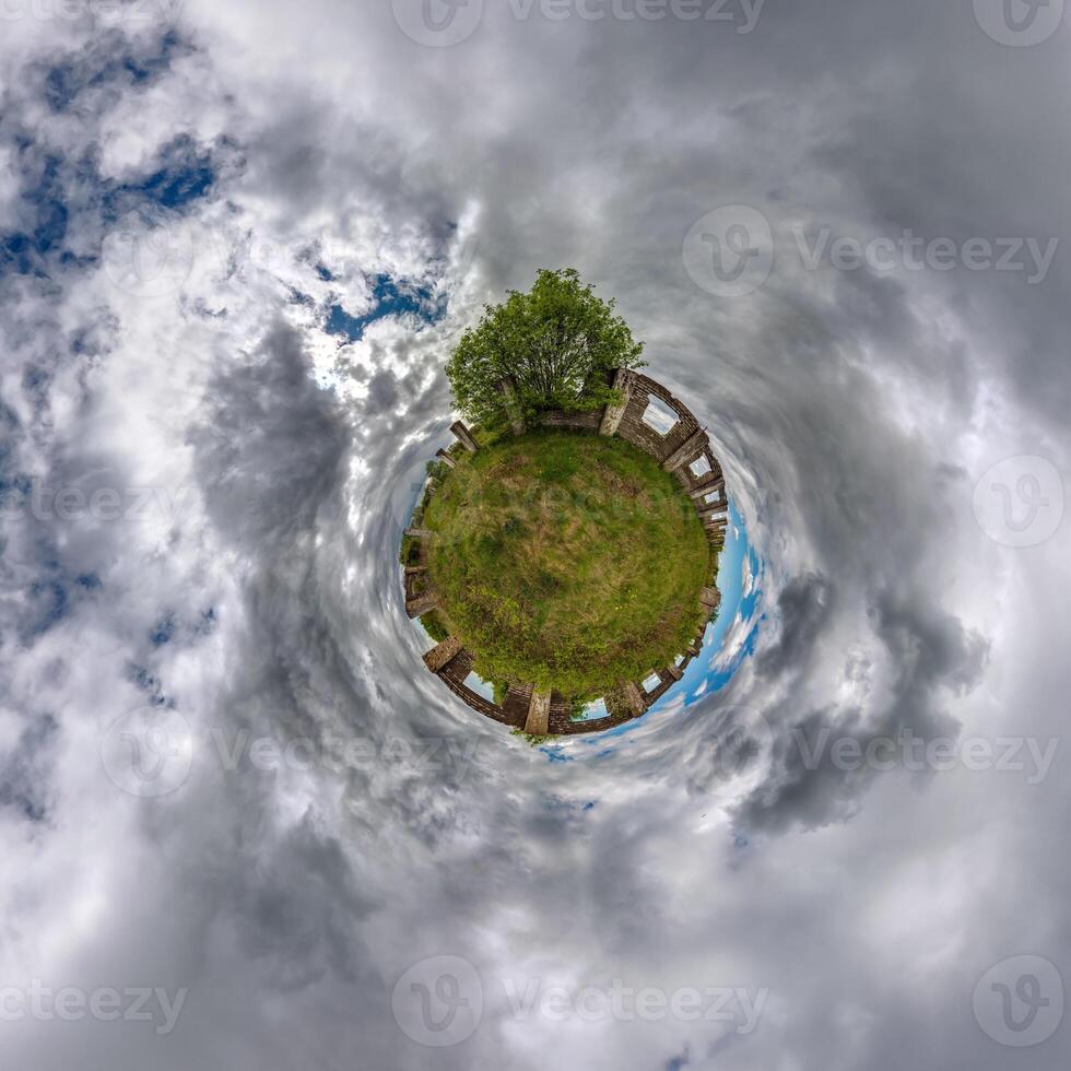 tiny planet in blue sky with clouds of old abandoned ruined church. Transformation of spherical 360 panorama in abstract aerial view. photo