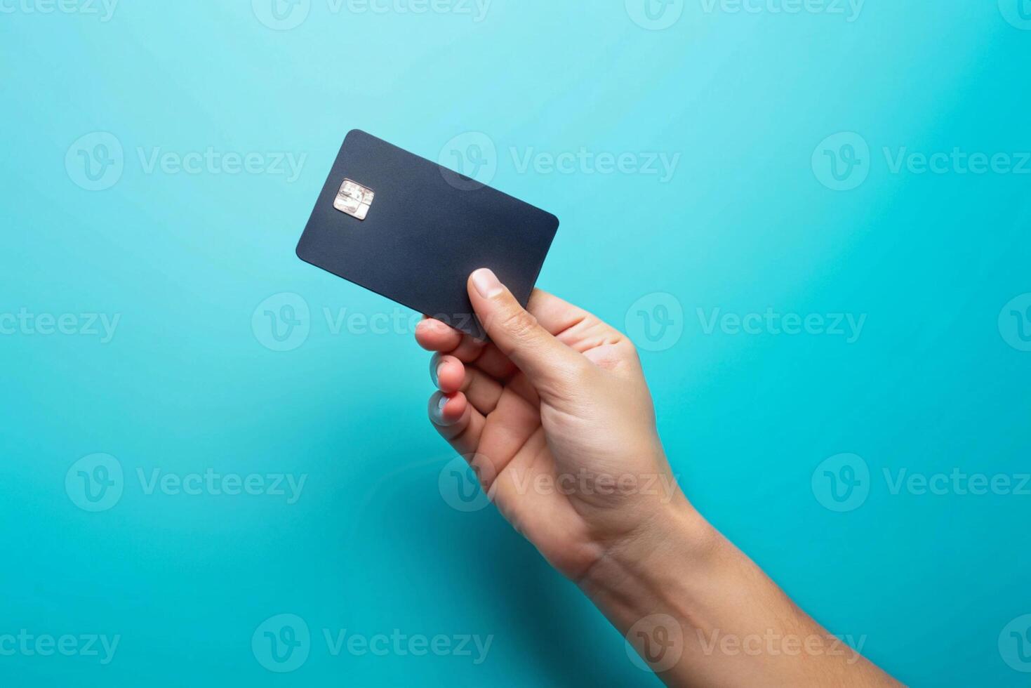 Blank black credit card isolated on blue background, photo studio hand hold blank credit card