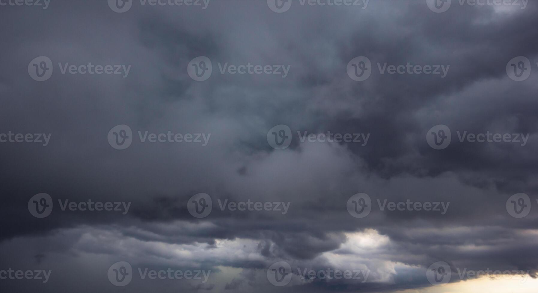 The dark sky with heavy clouds converging and a violent storm before the rain.Bad or moody weather sky and environment. carbon dioxide emissions, greenhouse effect, global warming, climate change photo