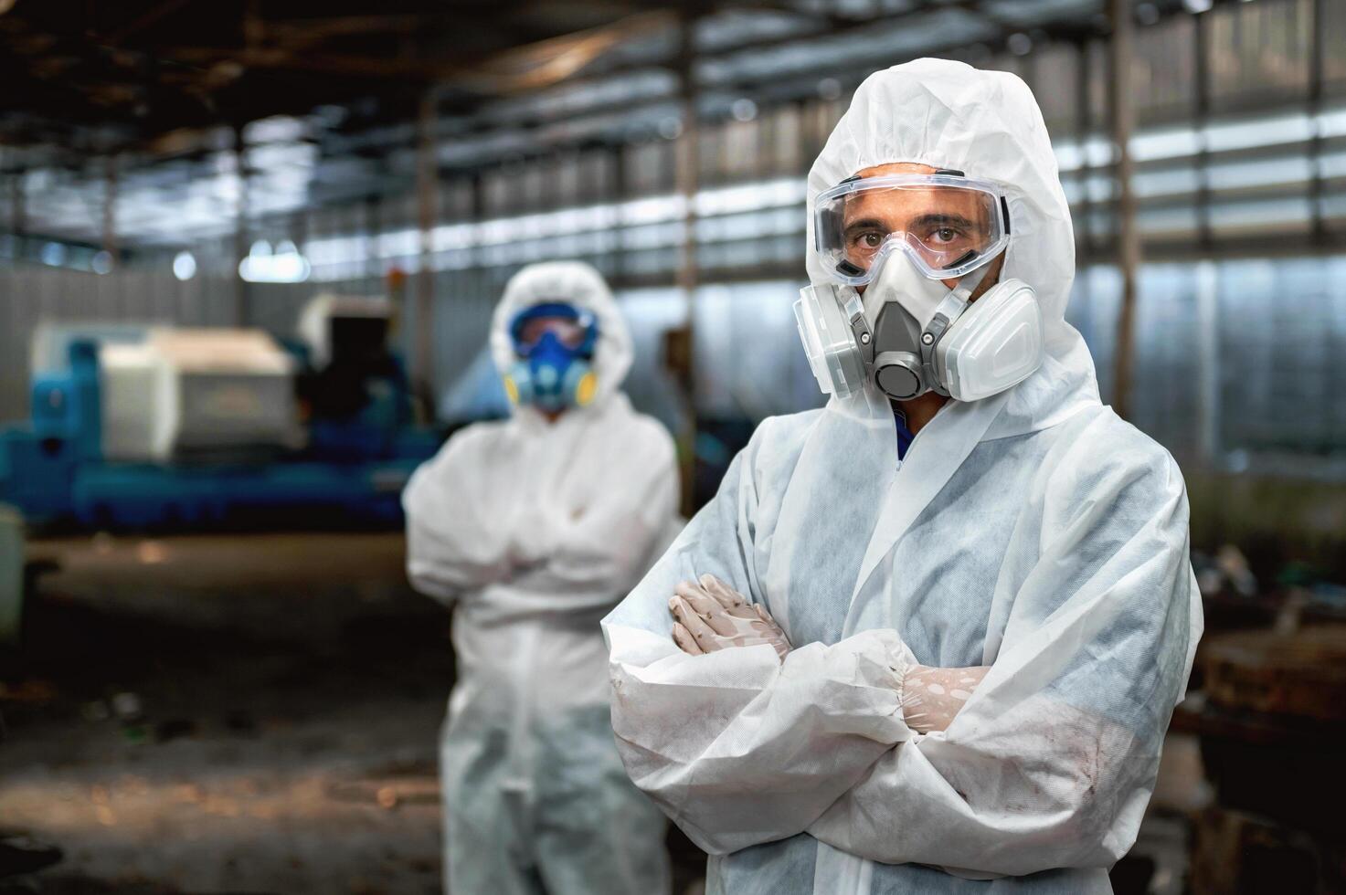 Two men in white protective gear stand in a factory photo