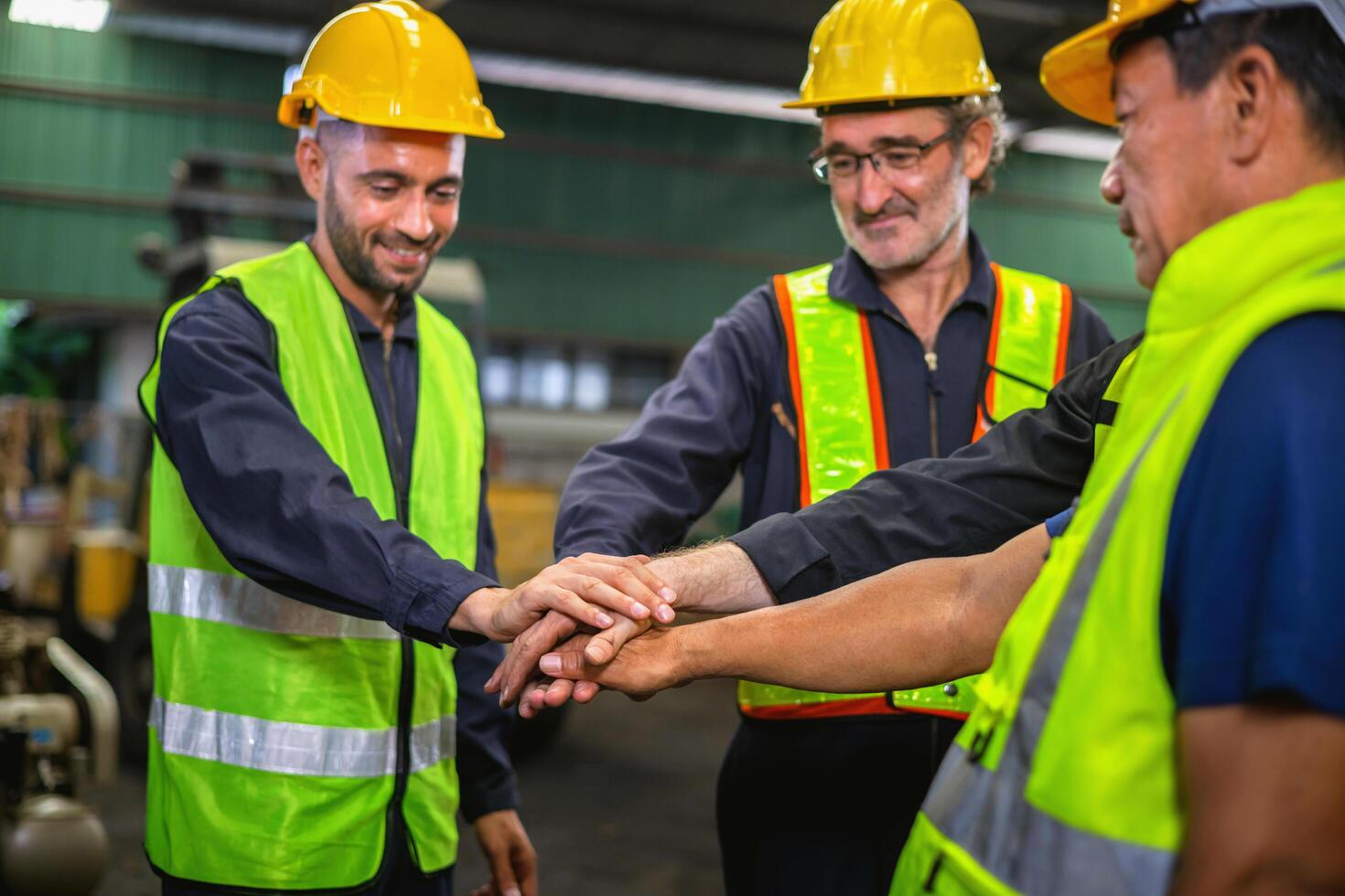 Three men in safety vests are shaking hands photo