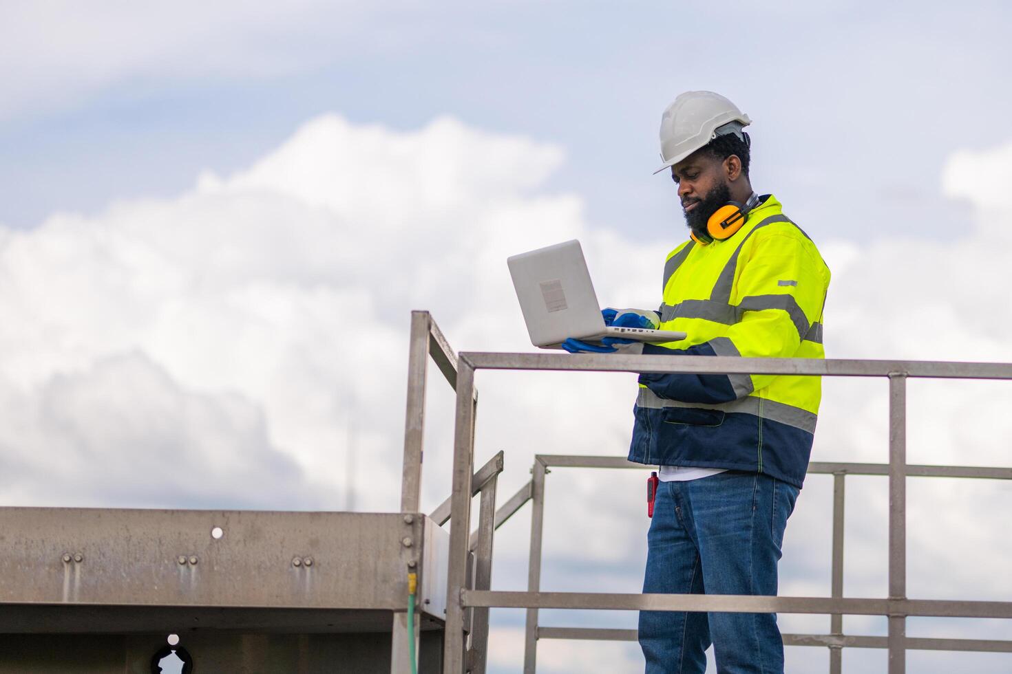 man holding solar panel in turbine farm photo