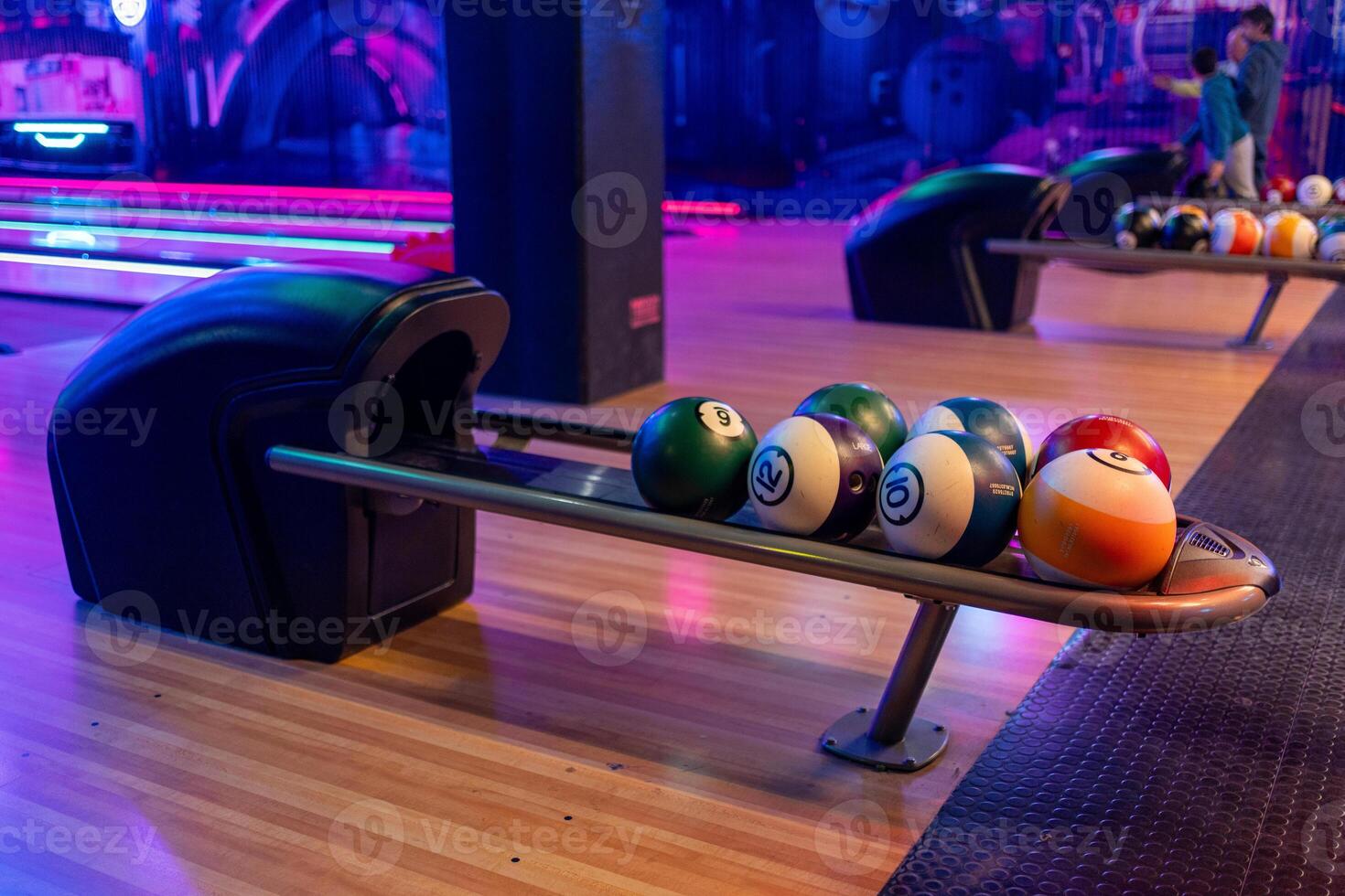 Modern bowling alley with ball rack and neon ultraviolet lights photo