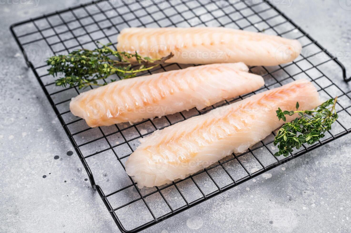 Fresh raw cod fish fillet, Boneless white fish meat. gray background. top view photo