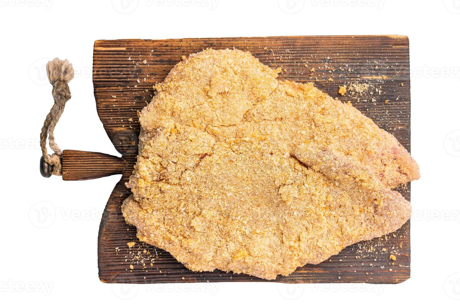 Ready for cooking Raw breaded Wiener Schnitzel steak on wooden board isolated on white background photo