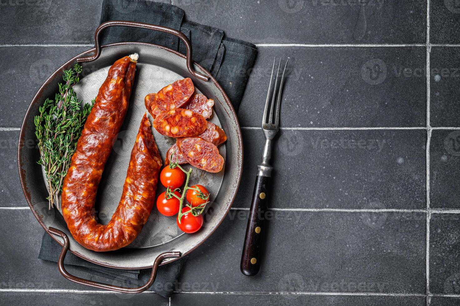 Sliced Chorizo sausage, slices of dry cured pork with herbs and spices. Black background. Top view. Copy space photo