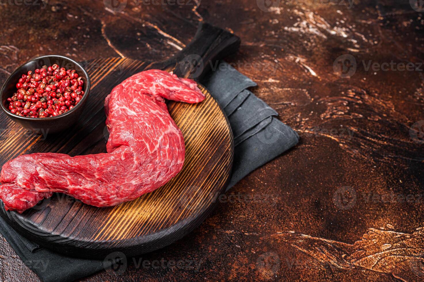 Raw Skirt Machete beef meat steak on wooden board. Dark background. Top view. Copy space photo