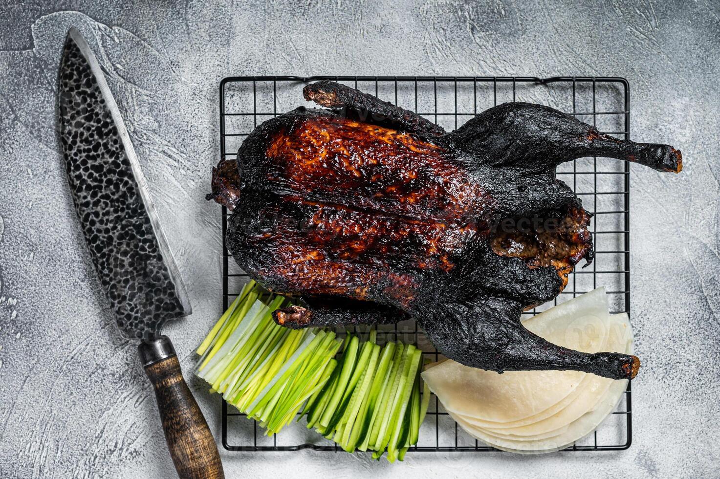 Whole roast Peking duck with herbs, sauce, rice Pancake, Cucumber and onion. White background. Top view photo