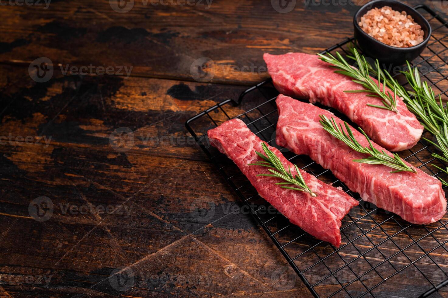 Raw Tri Tip Steak from Black Angus beef meat with rosemary. wooden background. top view photo