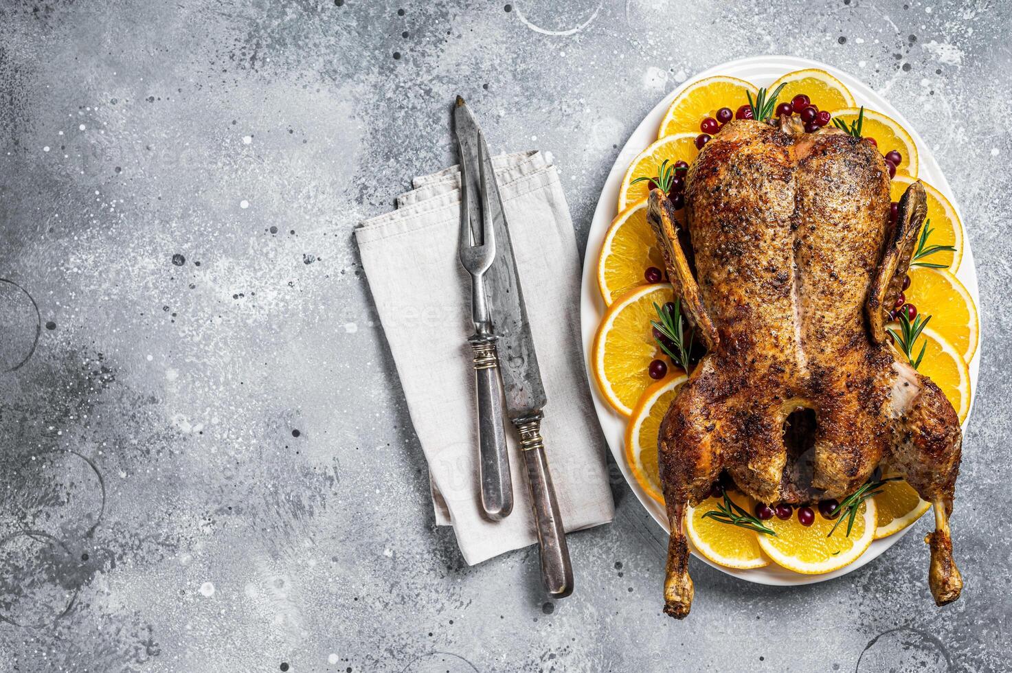 Christmas roast duck with apples and oranges, festive christmas recipe. Gray background. Top view. Copy space photo