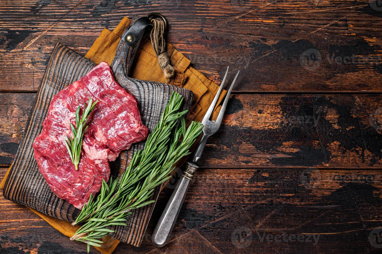 Raw alternative skirt beef steak on butcher board. Wooden background. Top view. Copy space photo