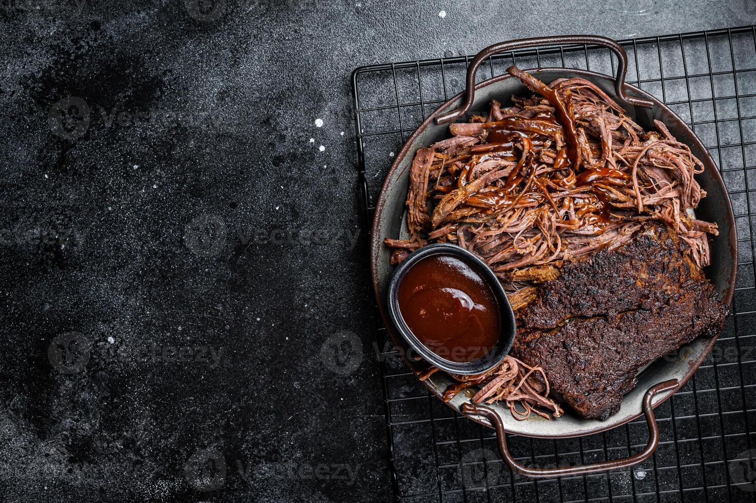 Slow Cooked Pulled Beef, Traditional meat rubbed with spices and smoked in a Texas smoker. Black background. Top view. Copy space photo