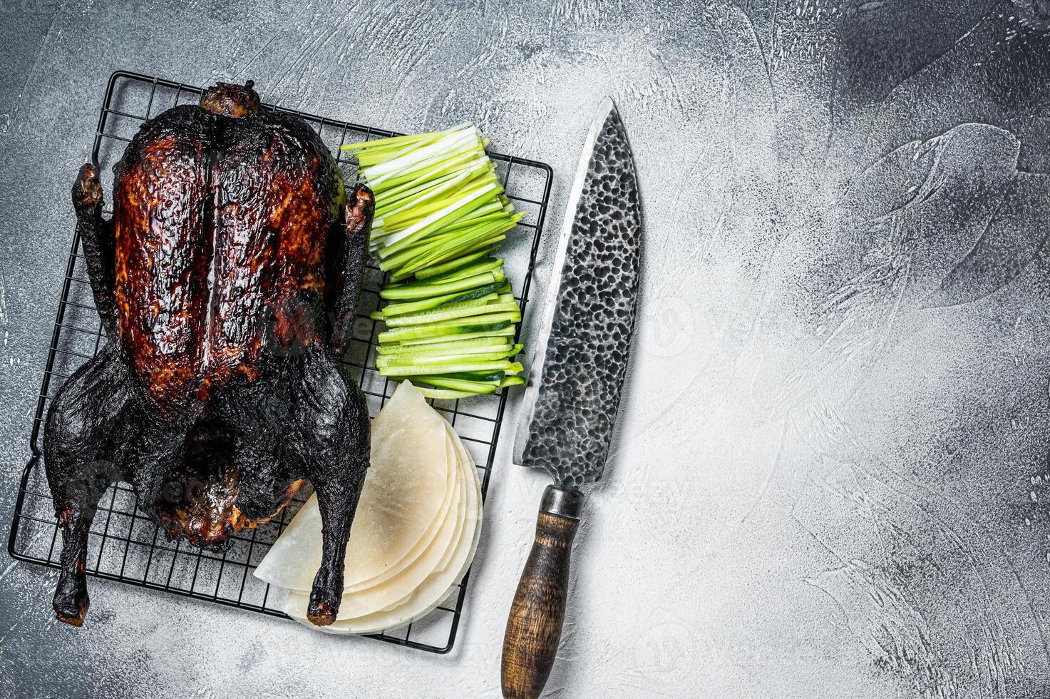 Whole roast Peking duck with herbs, sauce, rice Pancake, Cucumber and onion. White background. Top view. Copy space photo