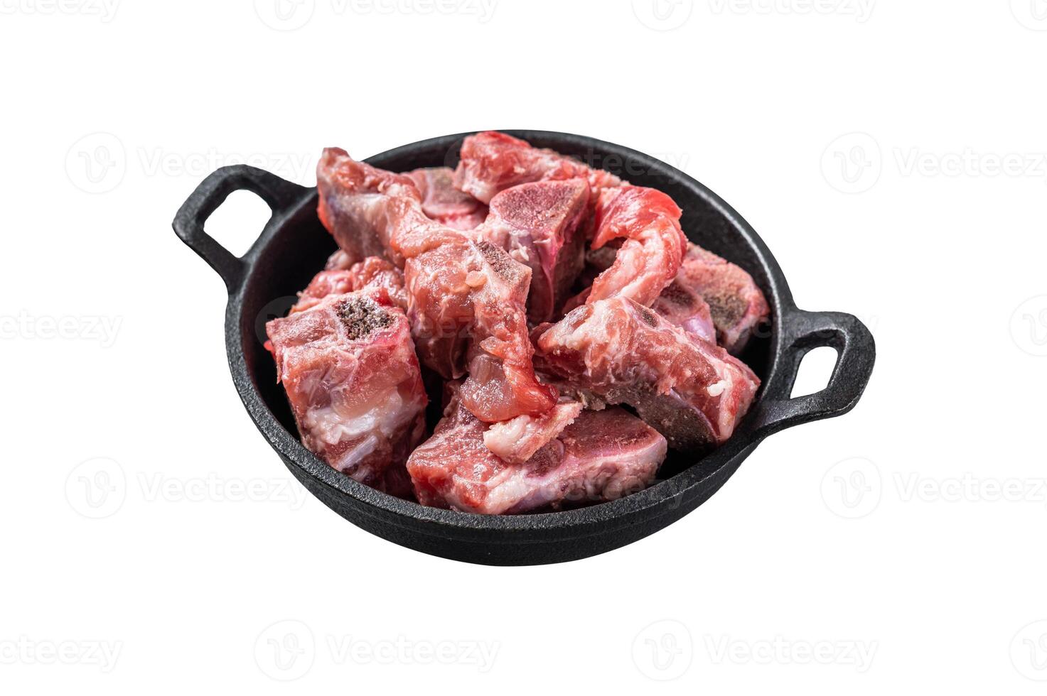 Raw diced meat cubes with bone in a pan. Isolated on white background. Top view. photo