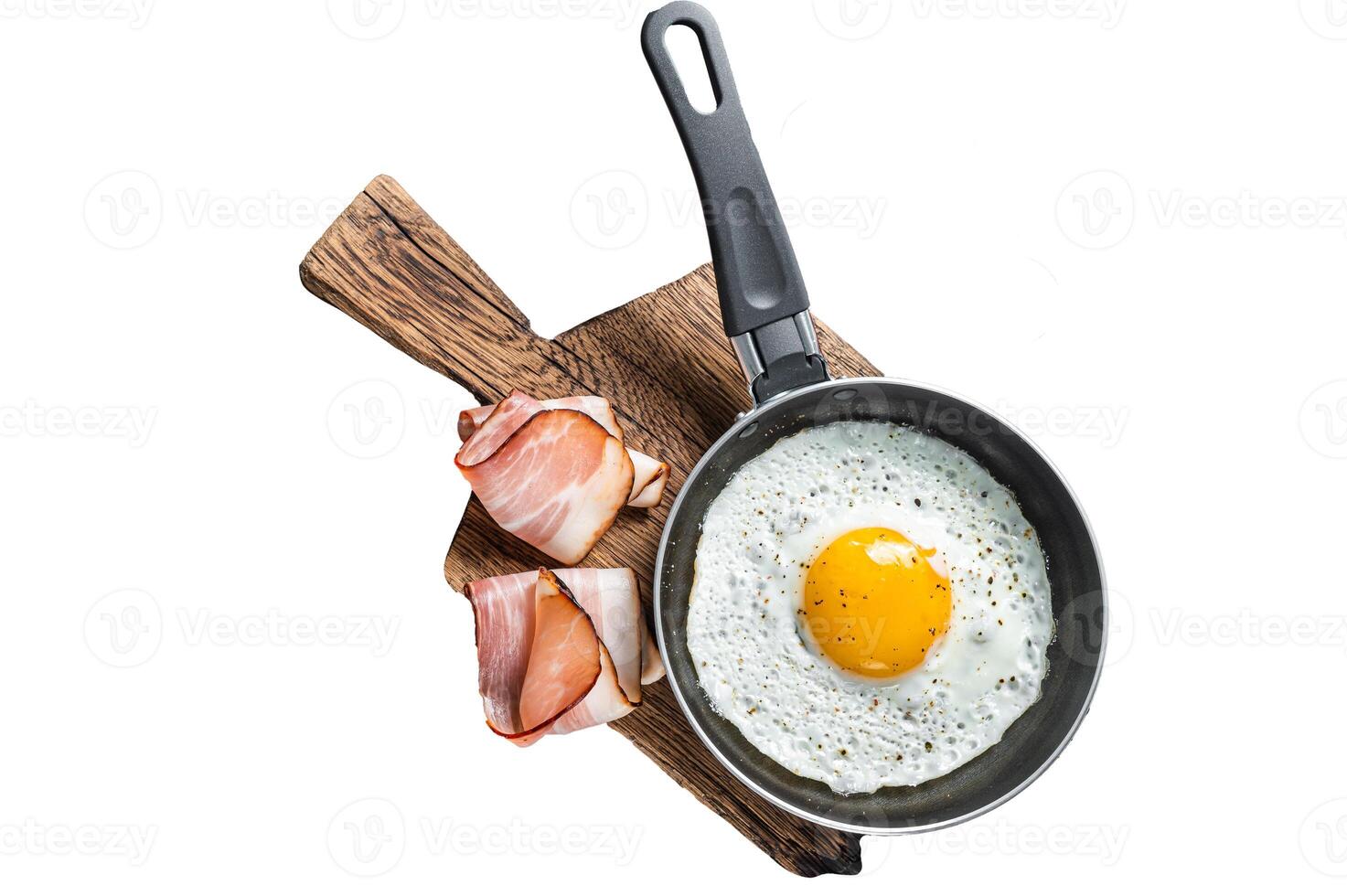 Fried egg in a frying pan with tomatoes and bacon. Isolated, white background. photo