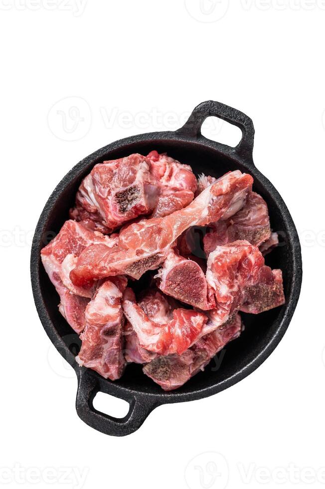 Raw diced meat cubes with bone in a pan. Isolated, white background. photo