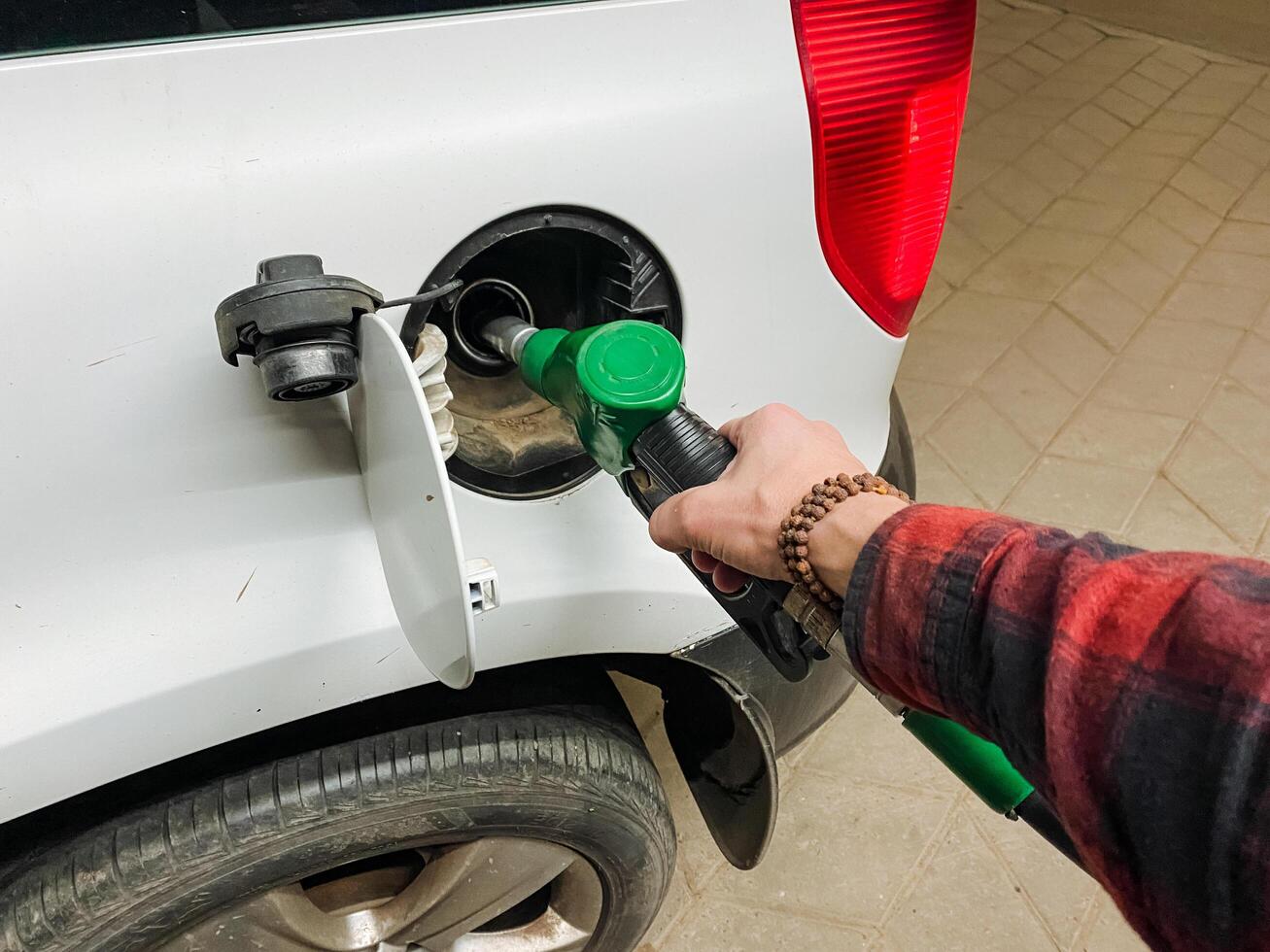 A person is actively engaged in the process of pumping gasoline into a cars fuel tank, ensuring that the tank is adequately filled for the journey that lies ahead of them photo