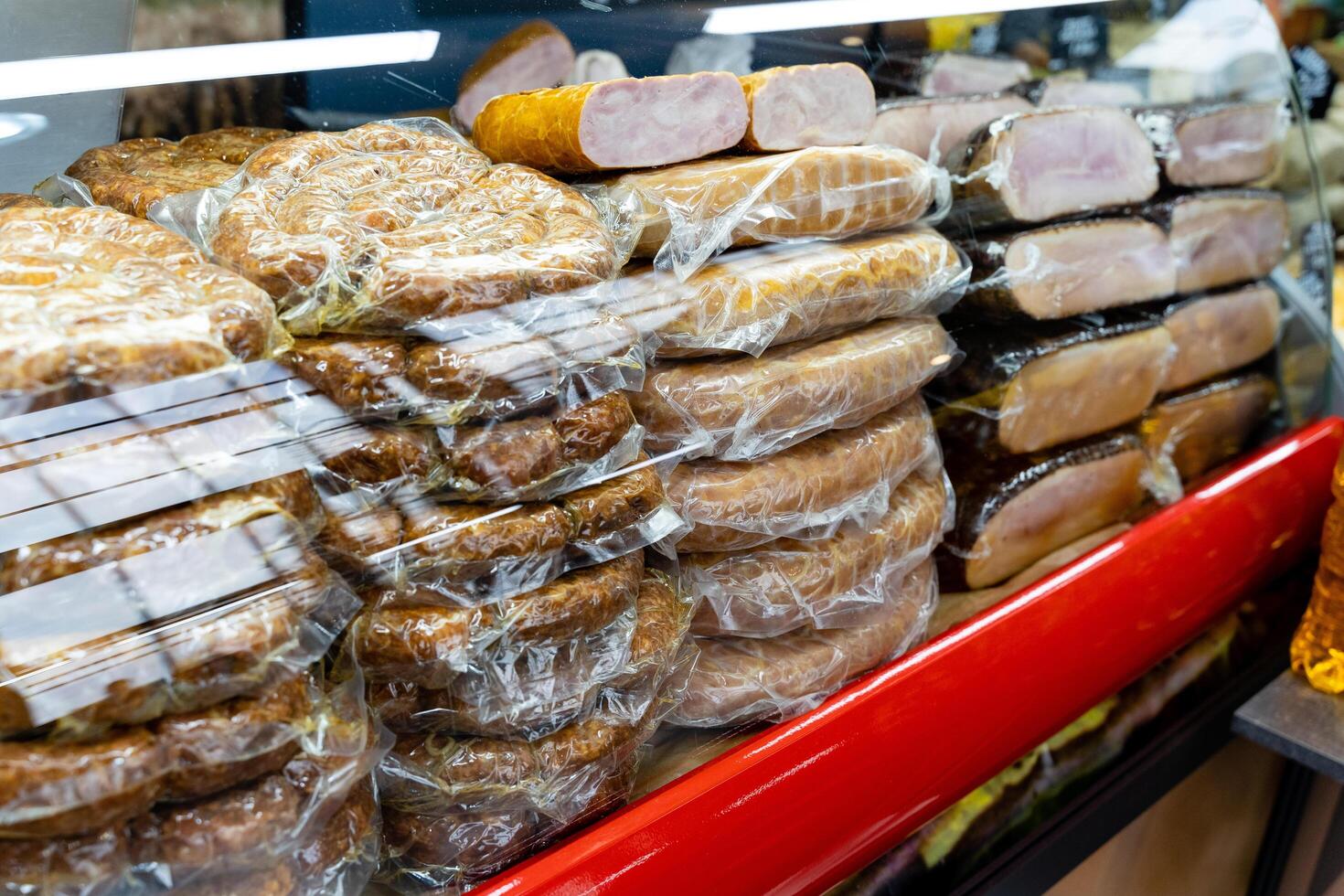 A display case that is filled with a wide variety of meats all in plastic wrap photo