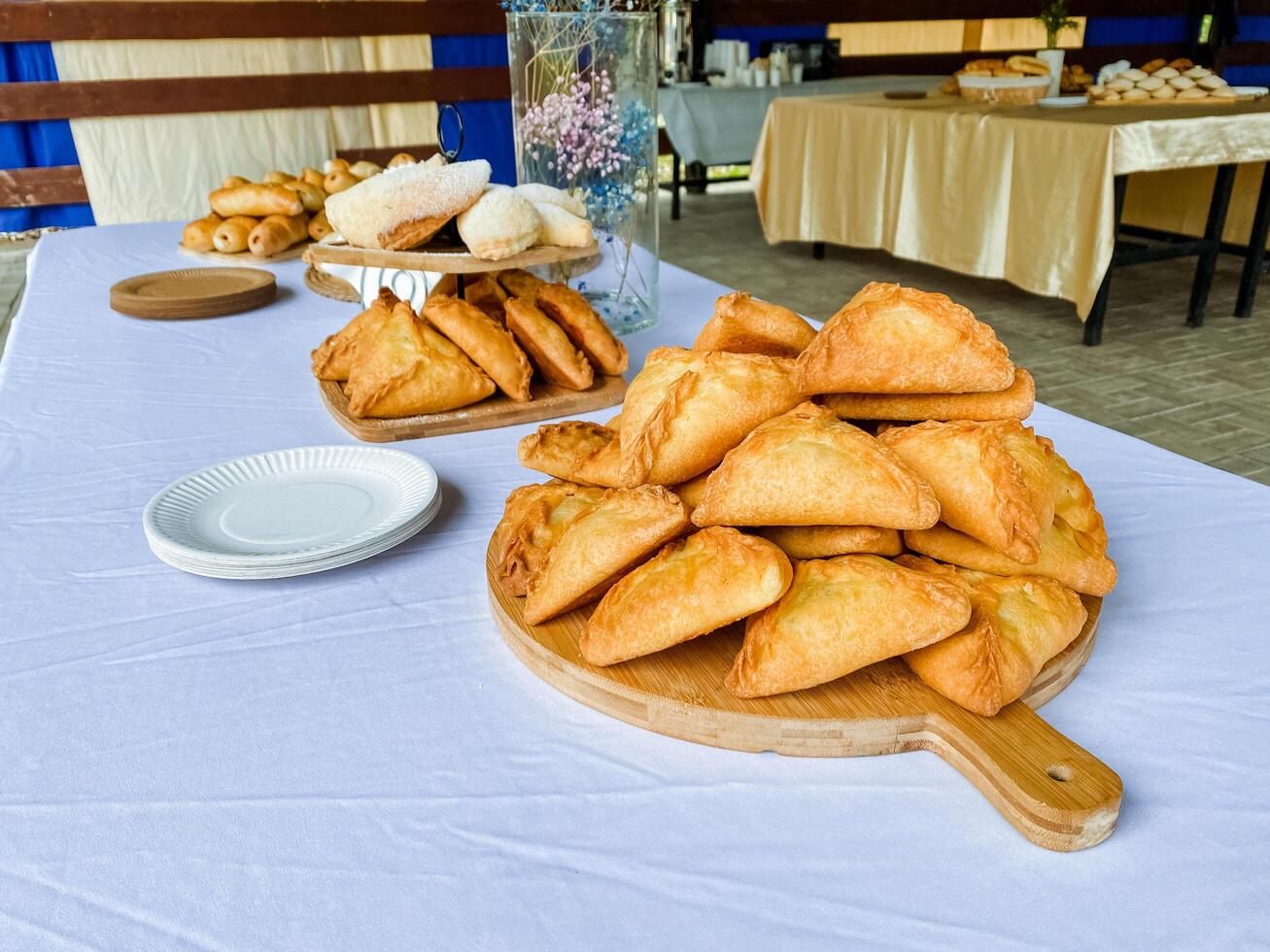 A beautifully crafted wooden cutting board showcases an array of delightful pastries artfully arranged on a lovely table, allowing everyone to easily access and enjoy these treats photo